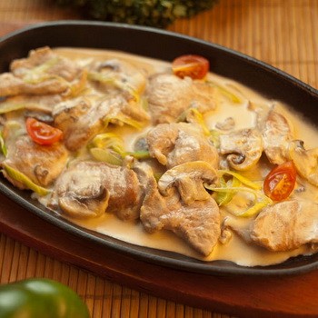 Stewed and fried meat with mushrooms in sour cream